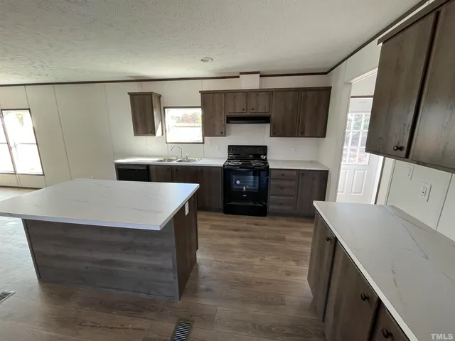 a large kitchen with cabinets wooden floor and stainless steel appliances