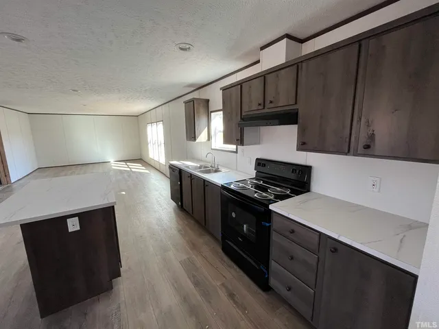 a kitchen with a sink a stove and cabinets