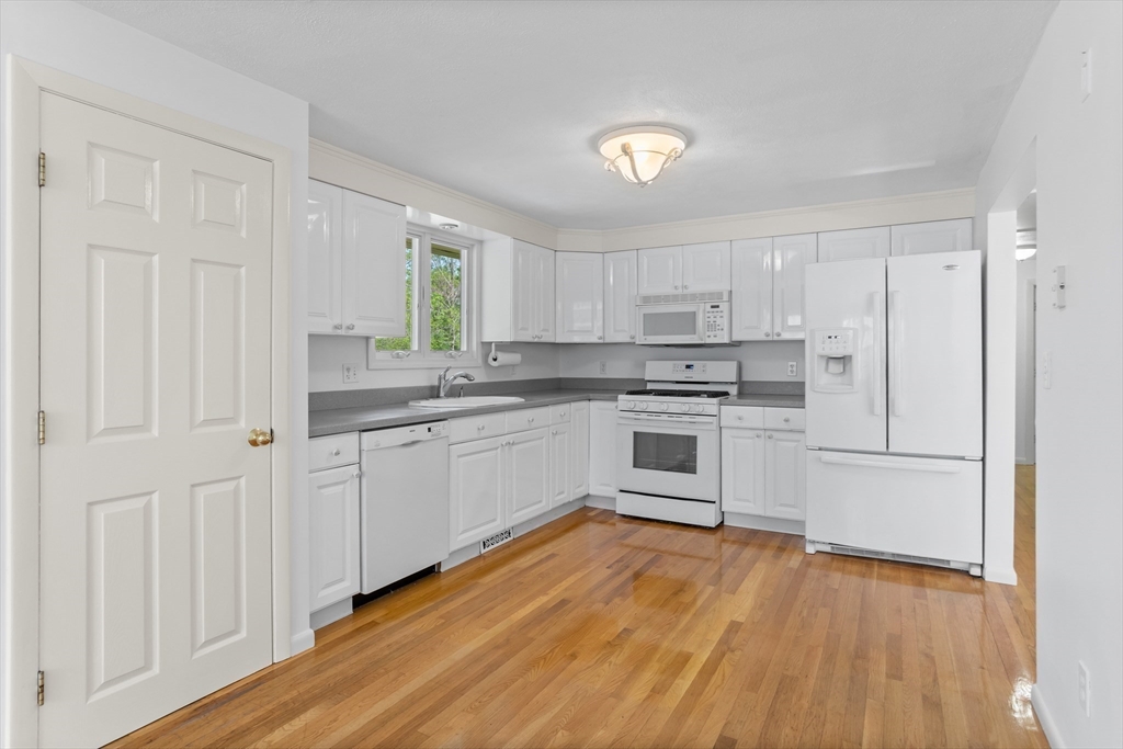 94 Codman Road Lincoln, MA 01773 - Photo 7 of 22 a kitchen with white cabinets and white appliances