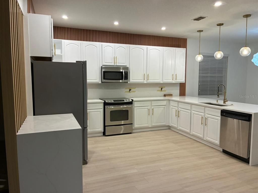 13225 Charfield Street Windermere, FL 34786 - Photo 8 of 40 a large kitchen with cabinets stainless steel appliances and a counter top