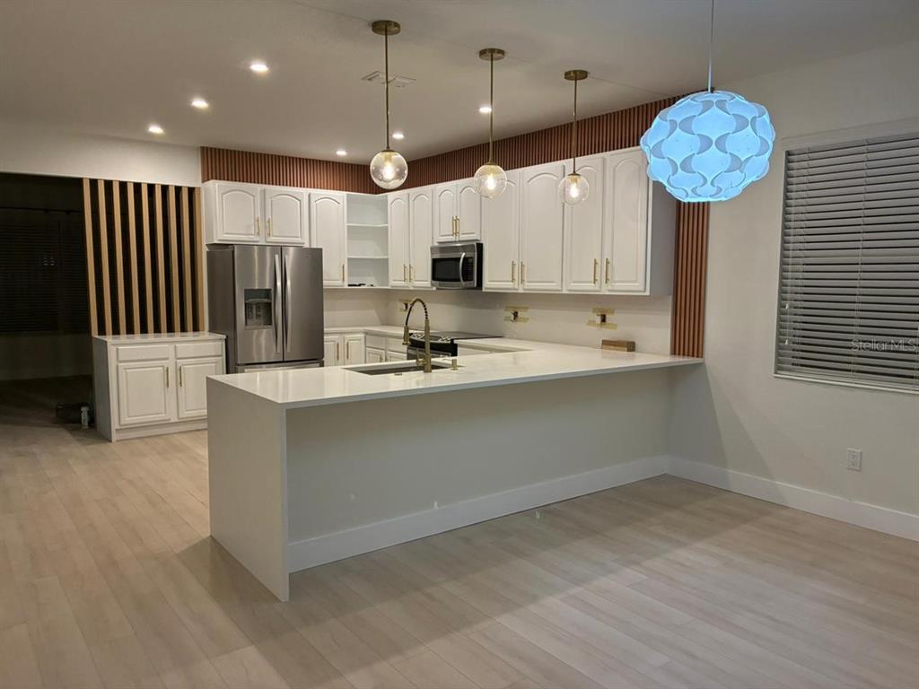 13225 Charfield Street Windermere, FL 34786 - Photo 9 of 40 a kitchen with a refrigerator a microwave oven and a sink