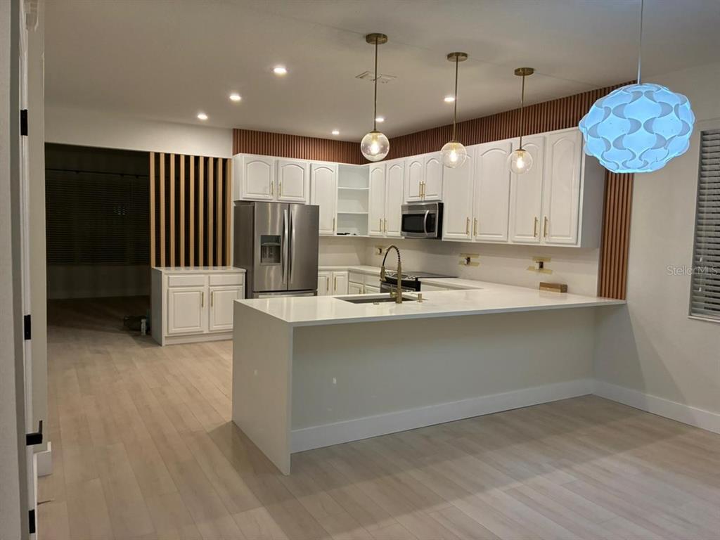 13225 Charfield Street Windermere, FL 34786 - Photo 10 of 40 a kitchen with kitchen island white cabinets and stainless steel appliances