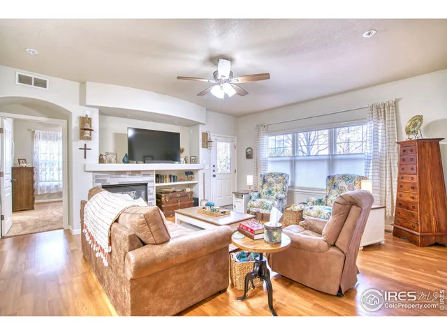 a living room with furniture a flat screen tv and a floor to ceiling window