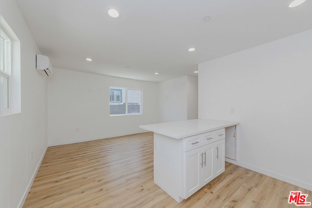1105 East 103rd Place Los Angeles, CA 90002 - Photo 16 of 56 a kitchen with a sink wooden floor and a living room view