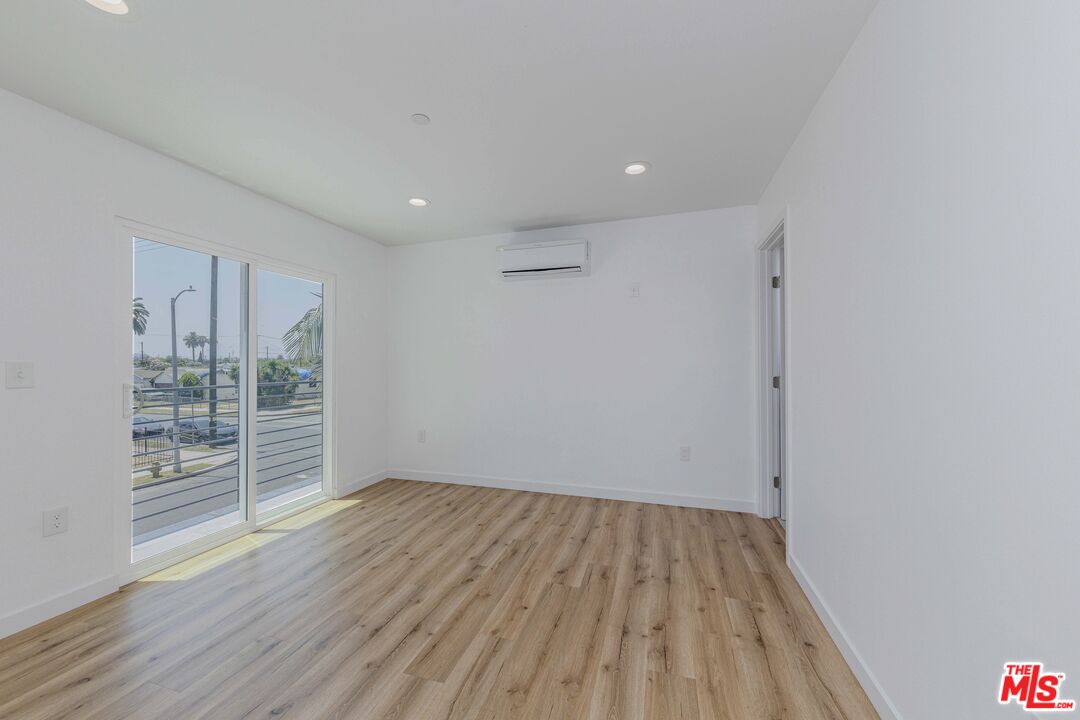 1105 East 103rd Place Los Angeles, CA 90002 - Photo 20 of 56 wooden floor in an empty room with a window