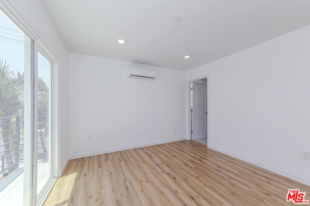 1105 East 103rd Place Los Angeles, CA 90002 - Photo 21 of 56 a view of empty room with wooden floor and fan