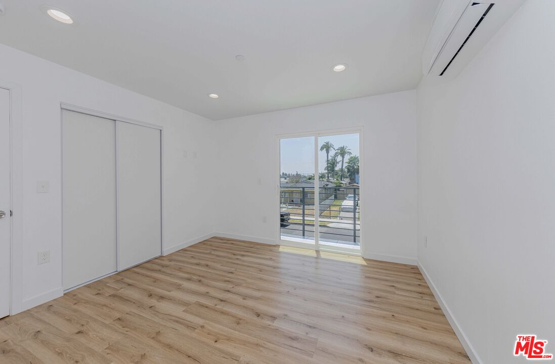 1105 East 103rd Place Los Angeles, CA 90002 - Photo 22 of 56 a view of an empty room with wooden floor and a window