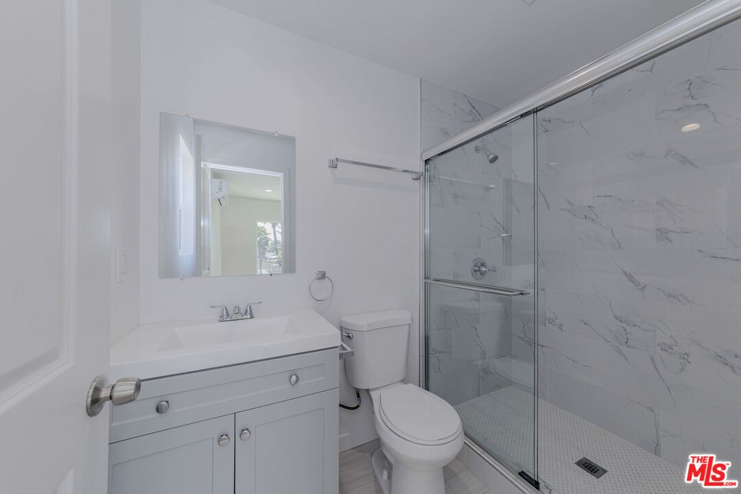 1105 East 103rd Place Los Angeles, CA 90002 - Photo 24 of 56 a bathroom with a shower sink vanity and toilet