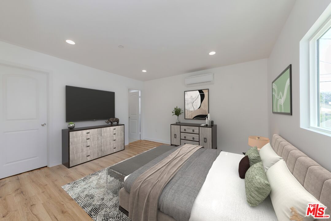 1105 East 103rd Place Los Angeles, CA 90002 - Photo 25 of 56 a bedroom with a bed and a flat screen tv