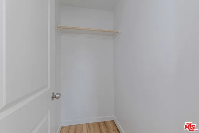 a living room with furniture kitchen view and a wooden floor