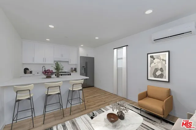 a living room with stainless steel appliances furniture and kitchen view