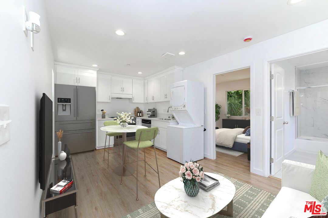1105 East 103rd Place Los Angeles, CA 90002 - Photo 34 of 56 a living room with furniture kitchen view and a wooden floor