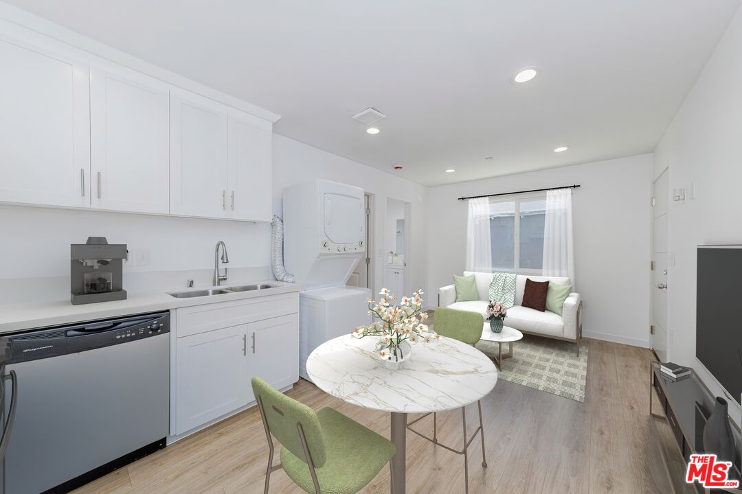 1105 East 103rd Place Los Angeles, CA 90002 - Photo 35 of 56 a kitchen with stainless steel appliances kitchen island granite countertop a sink and cabinets