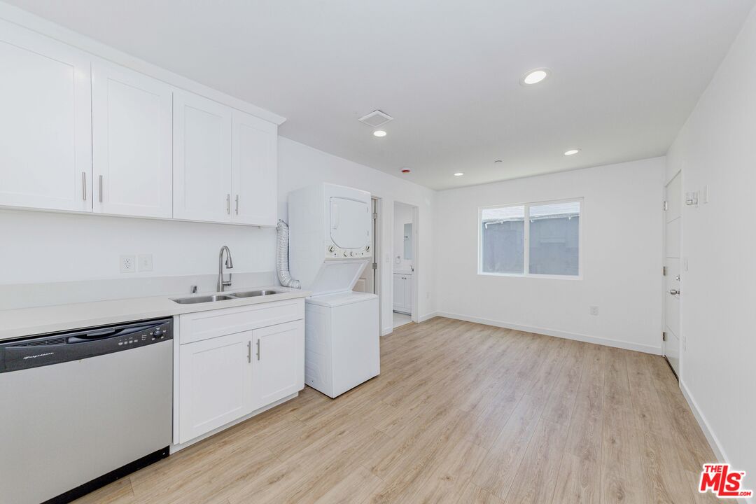 1105 East 103rd Place Los Angeles, CA 90002 - Photo 43 of 56 a kitchen with granite countertop white cabinets and white appliances