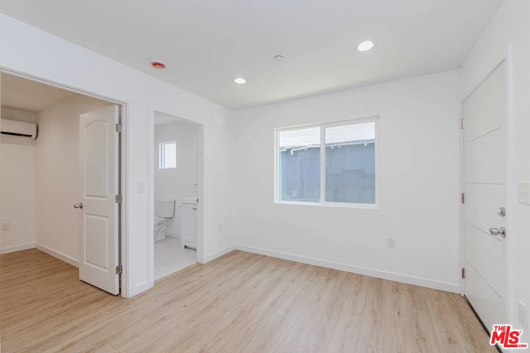 1105 East 103rd Place Los Angeles, CA 90002 - Photo 44 of 56 a view of a room with wooden floor and white walls