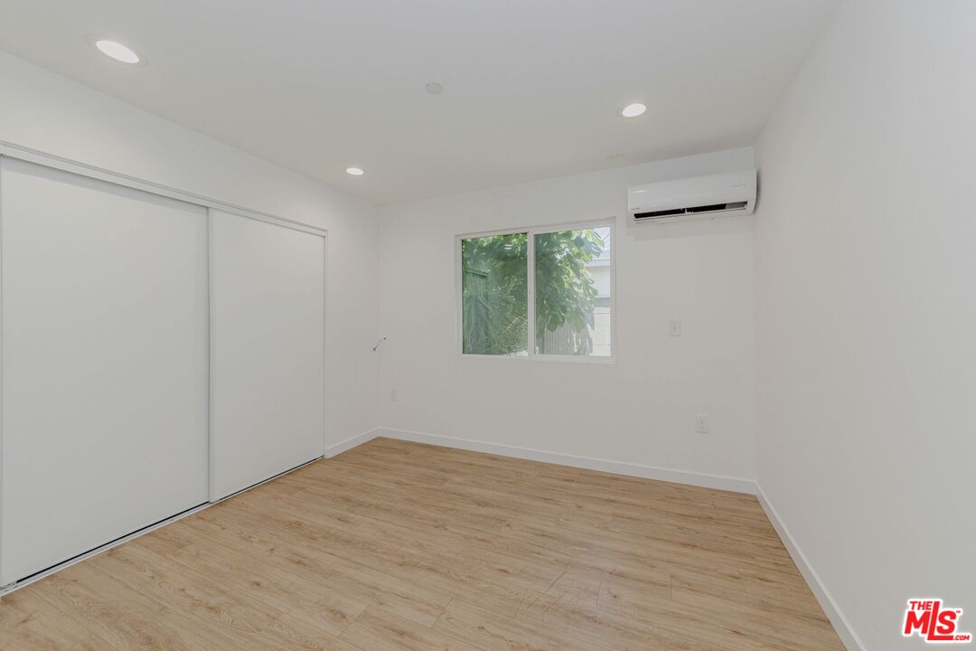 1105 East 103rd Place Los Angeles, CA 90002 - Photo 45 of 56 an empty room with wooden floor and windows