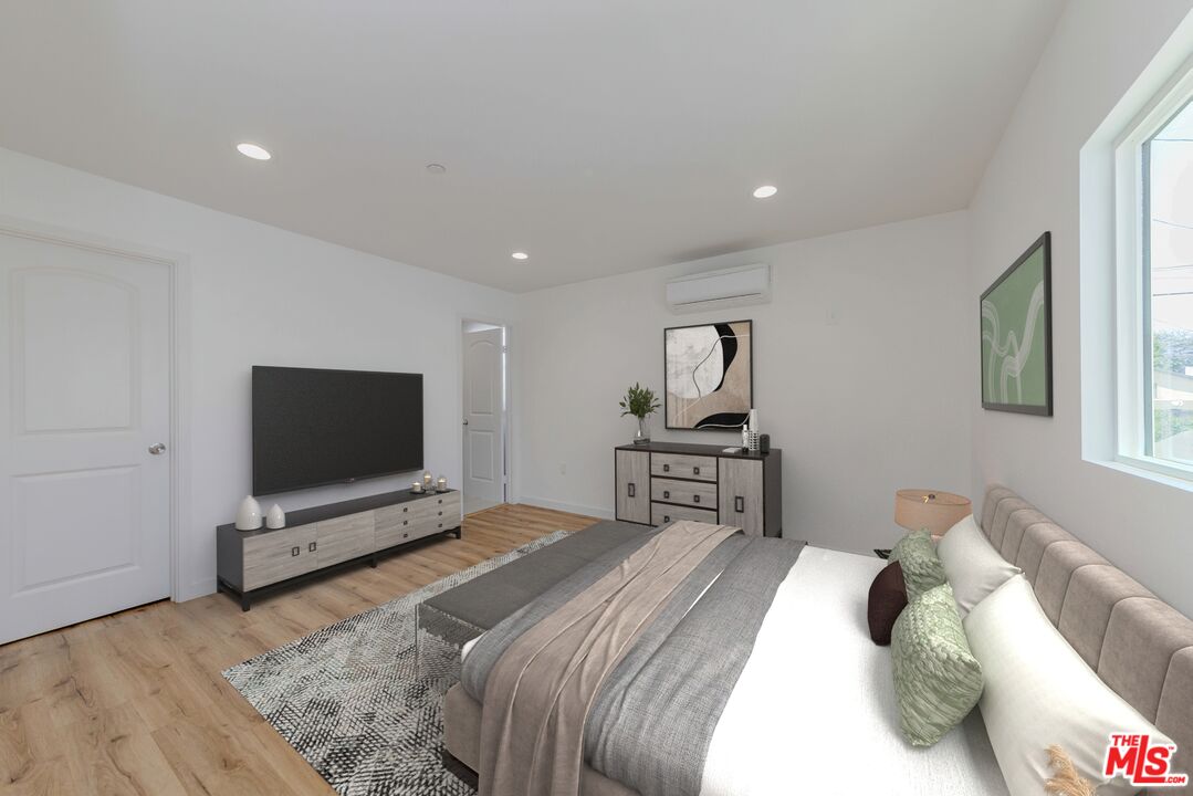 1105 East 103rd Place Los Angeles, CA 90002 - Photo 5 of 56 a bedroom with a bed tv on table and a window