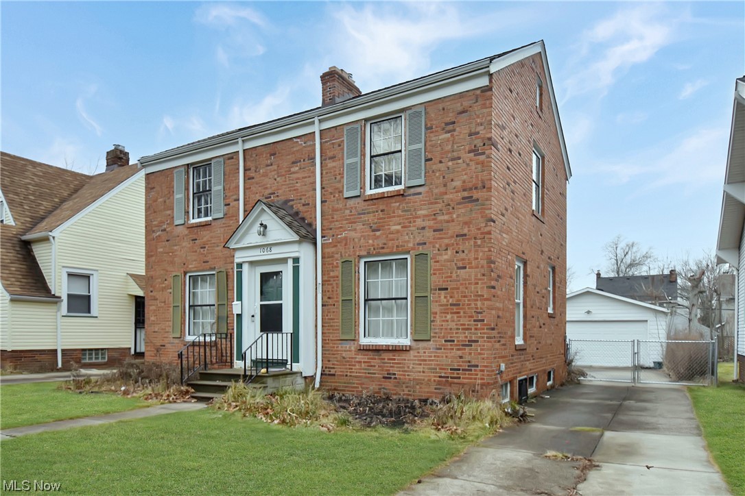 View of front facade featuring a garage and a front lawn