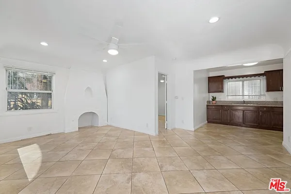 a kitchen with stainless steel appliances a sink a stove a refrigerator cabinets and a window