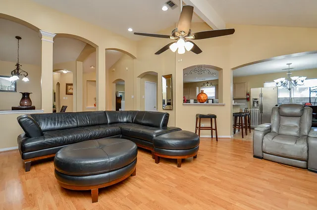 a living room with furniture and a wooden floor