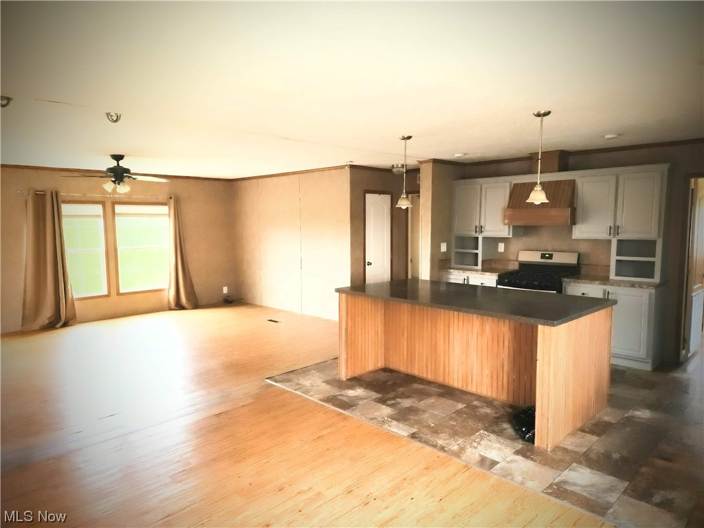 2925 Barth Road Belpre, OH 45714 - Photo 11 of 19 Kitchen featuring a kitchen island, gas range oven, pendant lighting, and laminate flooring
