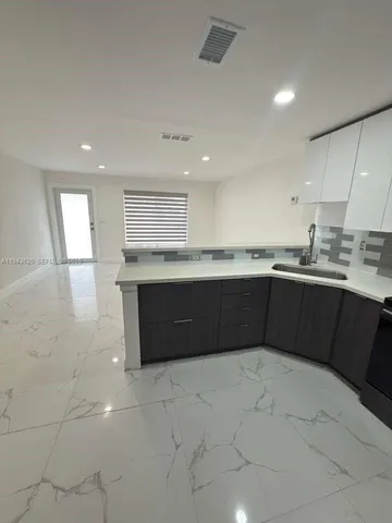 a kitchen with a sink a stove and cabinets