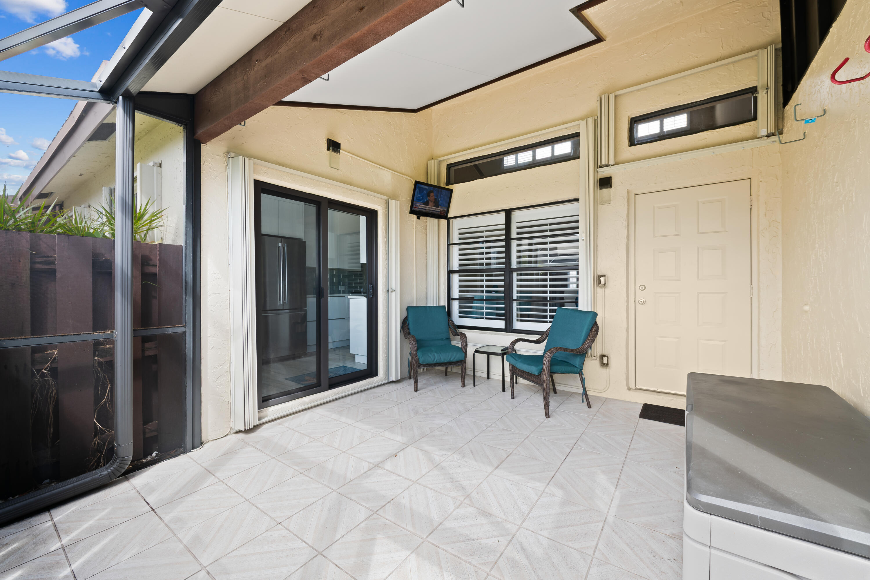 14067 Nesting Way, Unit C Delray Beach, FL 33484 - Photo 25 of 32 a view of a patio with table and chairs and floor to ceiling window with wooden fence