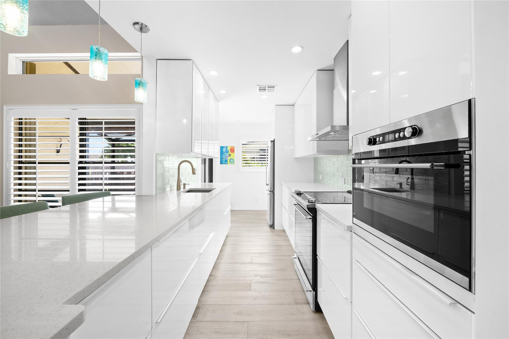 14067 Nesting Way, Unit C Delray Beach, FL 33484 - Photo 3 of 32 a view of a kitchen with a stove a fridge and wooden floor