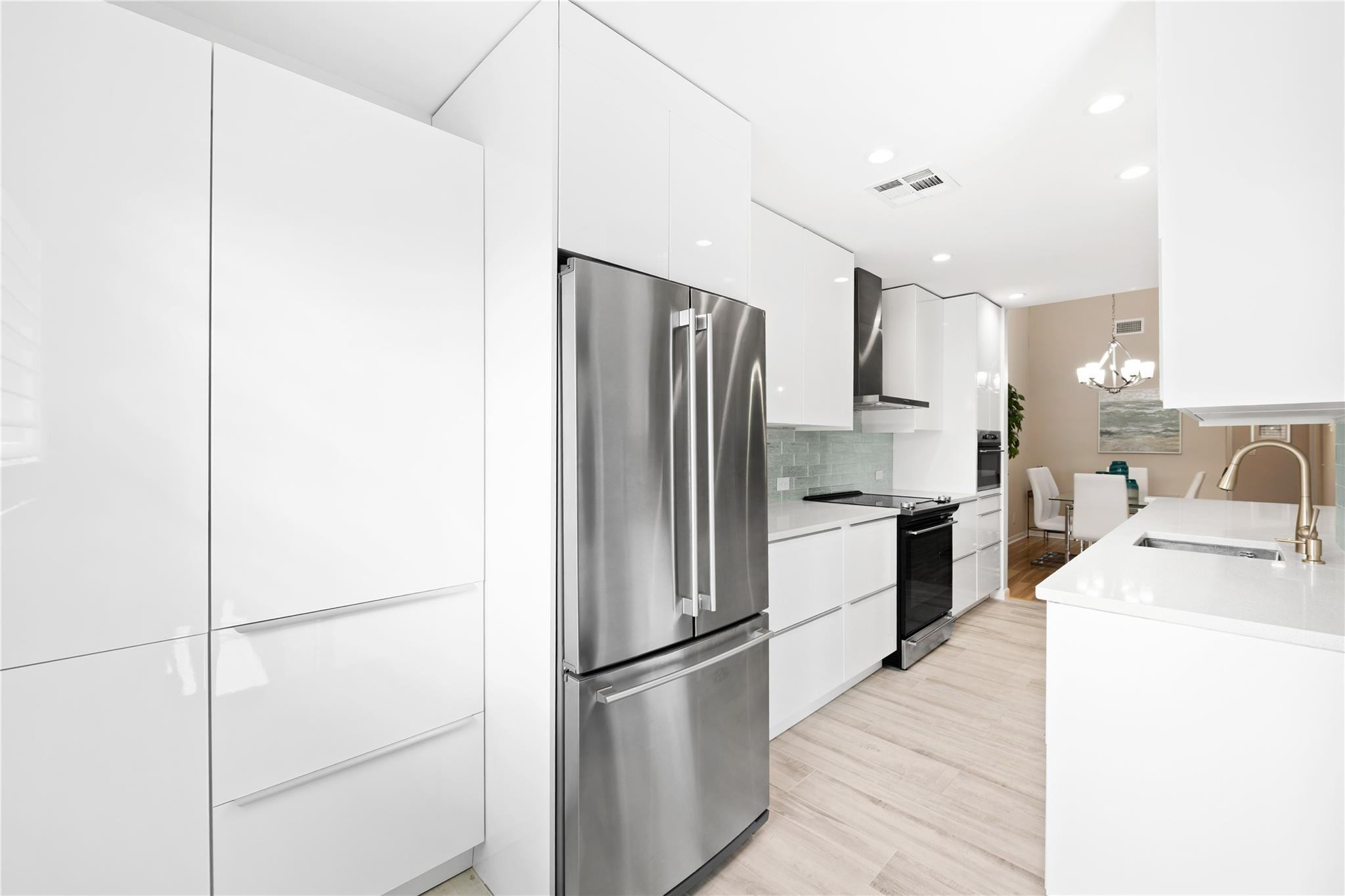 14067 Nesting Way, Unit C Delray Beach, FL 33484 - Photo 6 of 32 a kitchen with a refrigerator sink and wooden floor