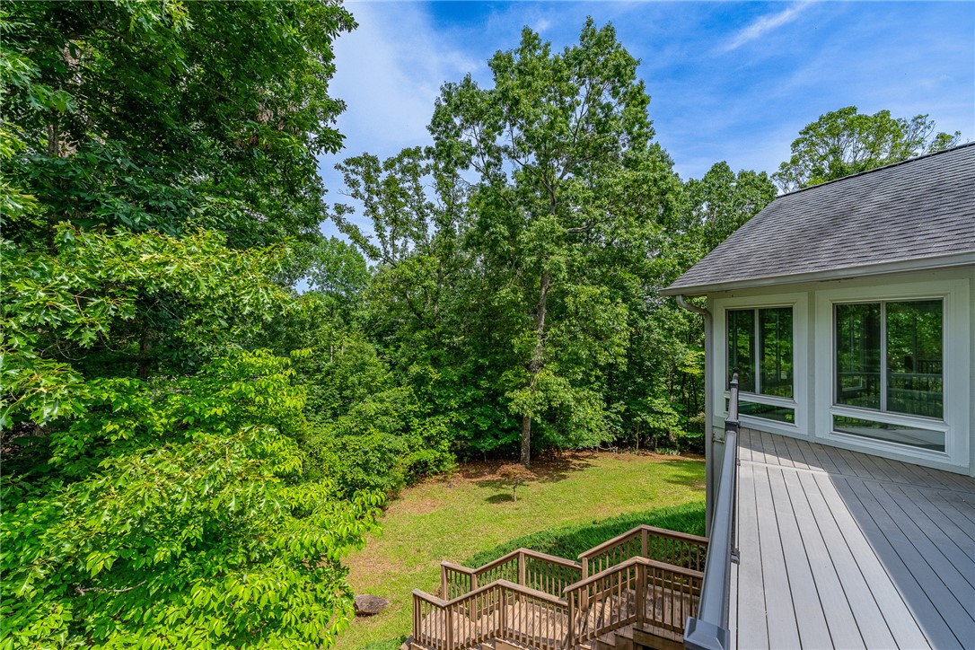 118 Beacon Ridge Circle Salem, SC 29676 - Photo 32 of 45 A spacious outdoor deck with stairs descends to a lush, private yard surrounded by mature trees.