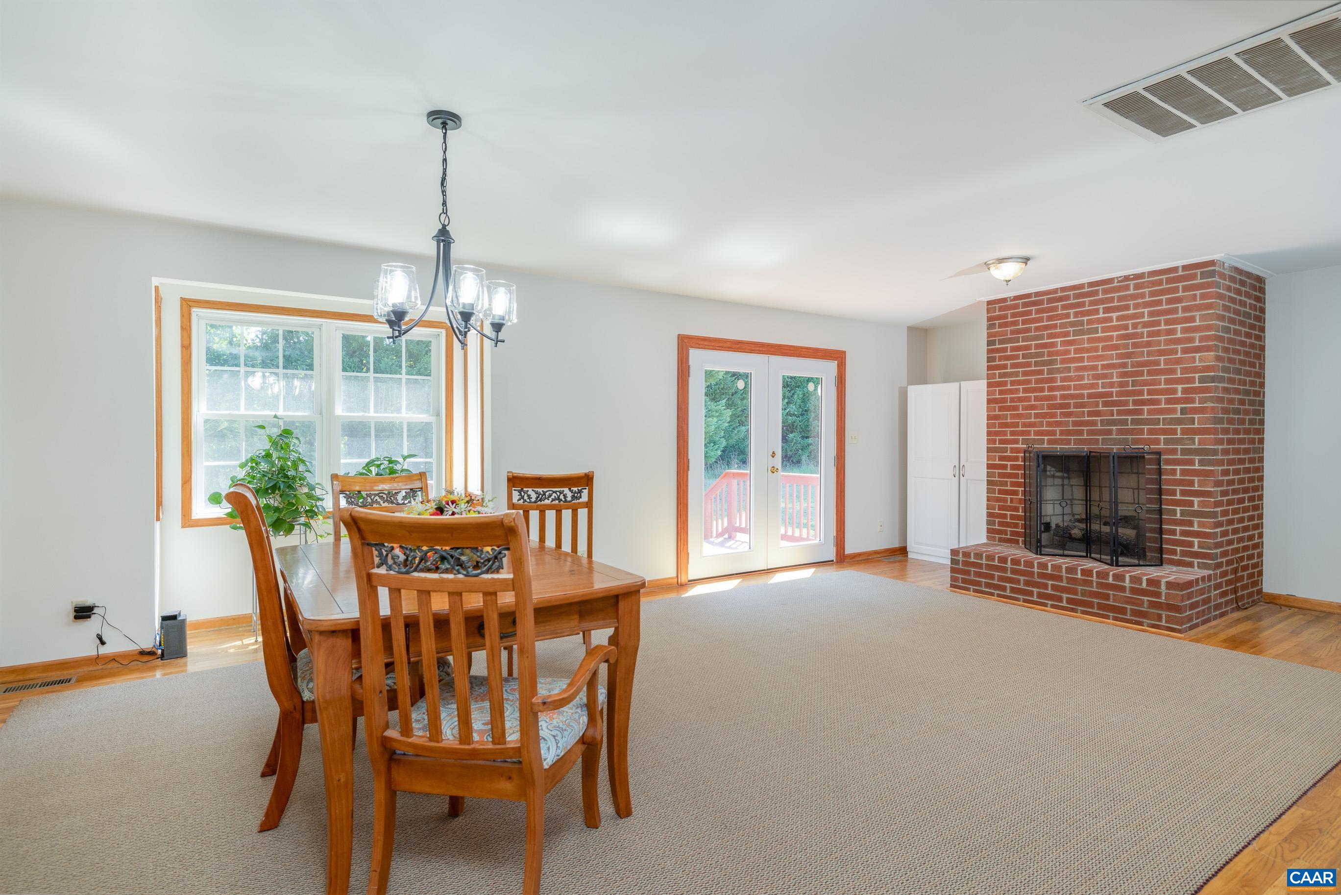 7839 Venable Road Kents Store, VA 23084 - Photo 17 of 51 a dining room with furniture a chandelier and fireplace