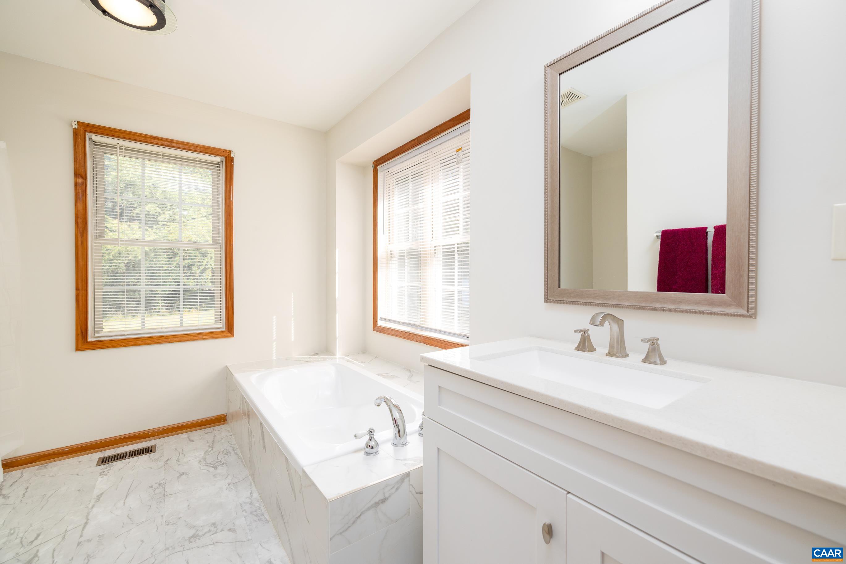 7839 Venable Road Kents Store, VA 23084 - Photo 24 of 51 a bathroom with a tub sink and mirror