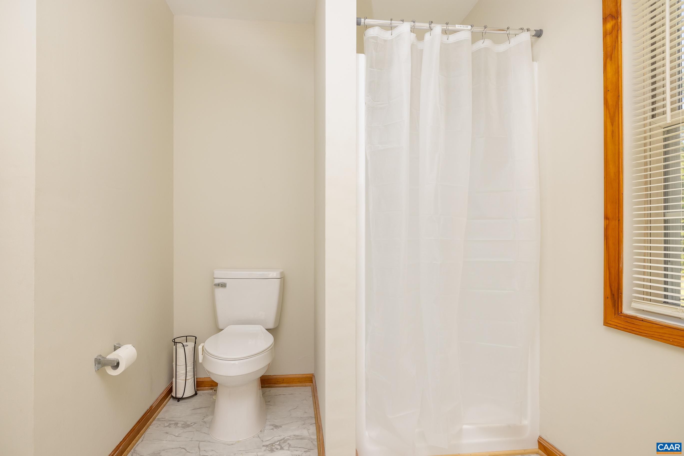 7839 Venable Road Kents Store, VA 23084 - Photo 27 of 51 a white toilet sitting next to a shower curtain
