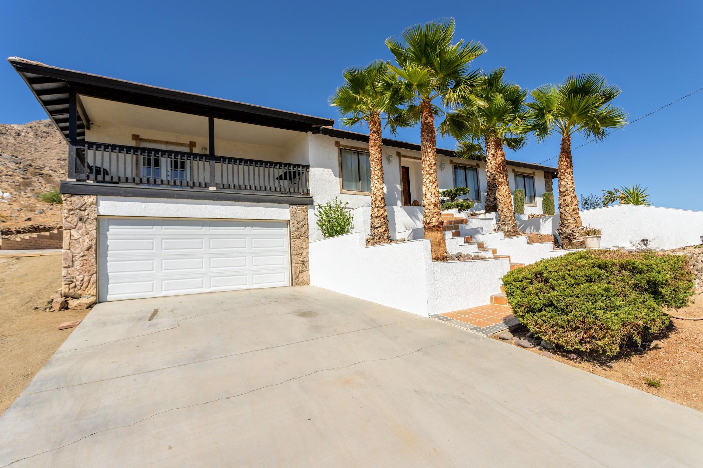 16276 Rancherias Road Apple Valley, CA 92307 - Photo 1 of 27 a front view of a house with a yard and a garage