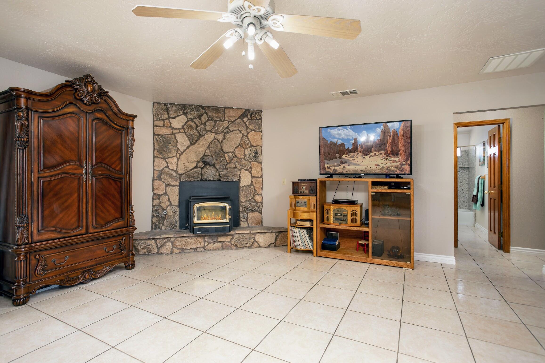 16276 Rancherias Road Apple Valley, CA 92307 - Photo 14 of 27 a living room with furniture a flat screen tv and a fireplace