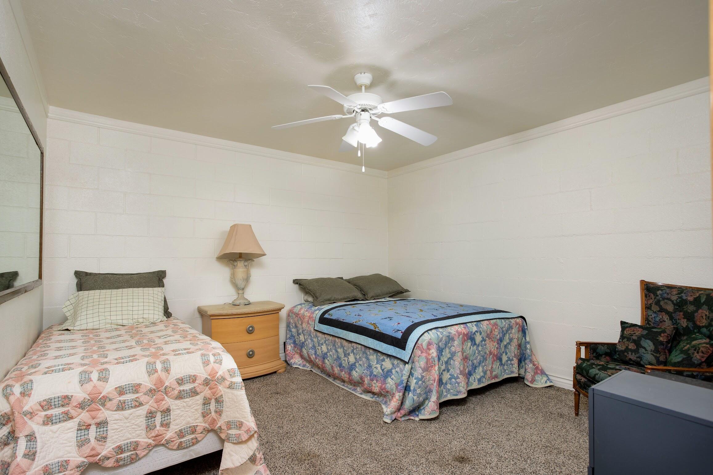 16276 Rancherias Road Apple Valley, CA 92307 - Photo 18 of 27 a bedroom with a bed and a chandelier