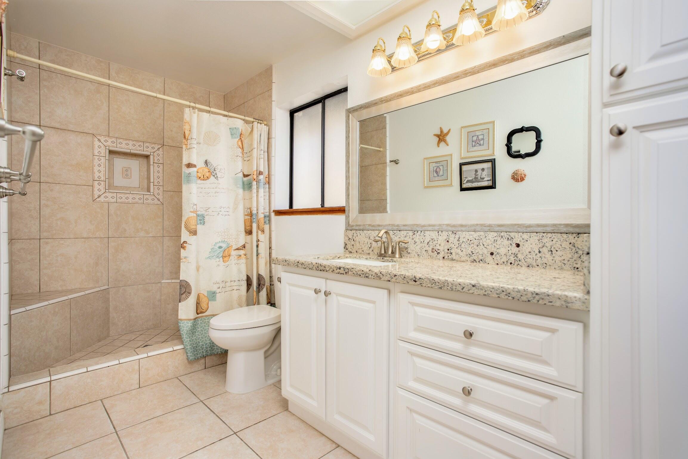 16276 Rancherias Road Apple Valley, CA 92307 - Photo 19 of 27 a bathroom with a granite countertop sink a toilet and a shower