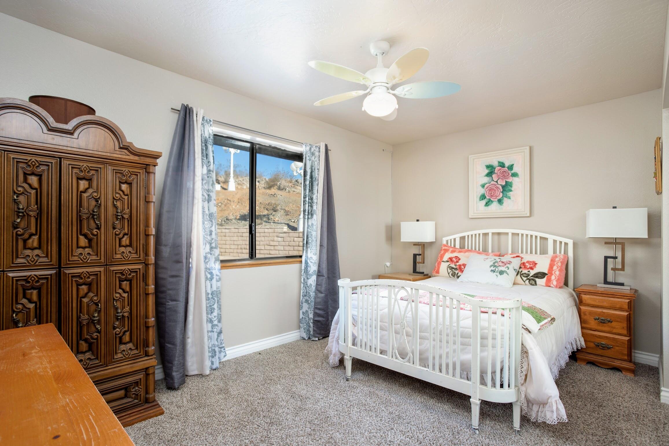 16276 Rancherias Road Apple Valley, CA 92307 - Photo 20 of 27 a bedroom with a bed and a chandelier