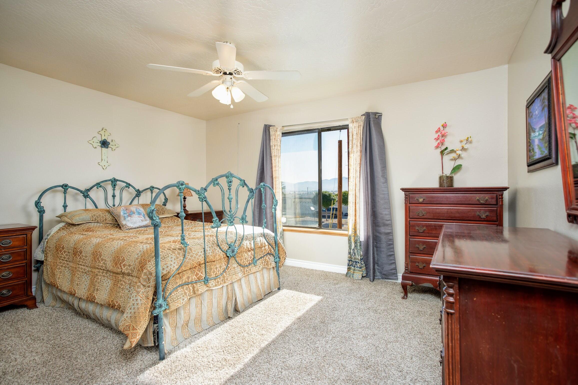 16276 Rancherias Road Apple Valley, CA 92307 - Photo 21 of 27 a bedroom with a bed next to a window with the outer view