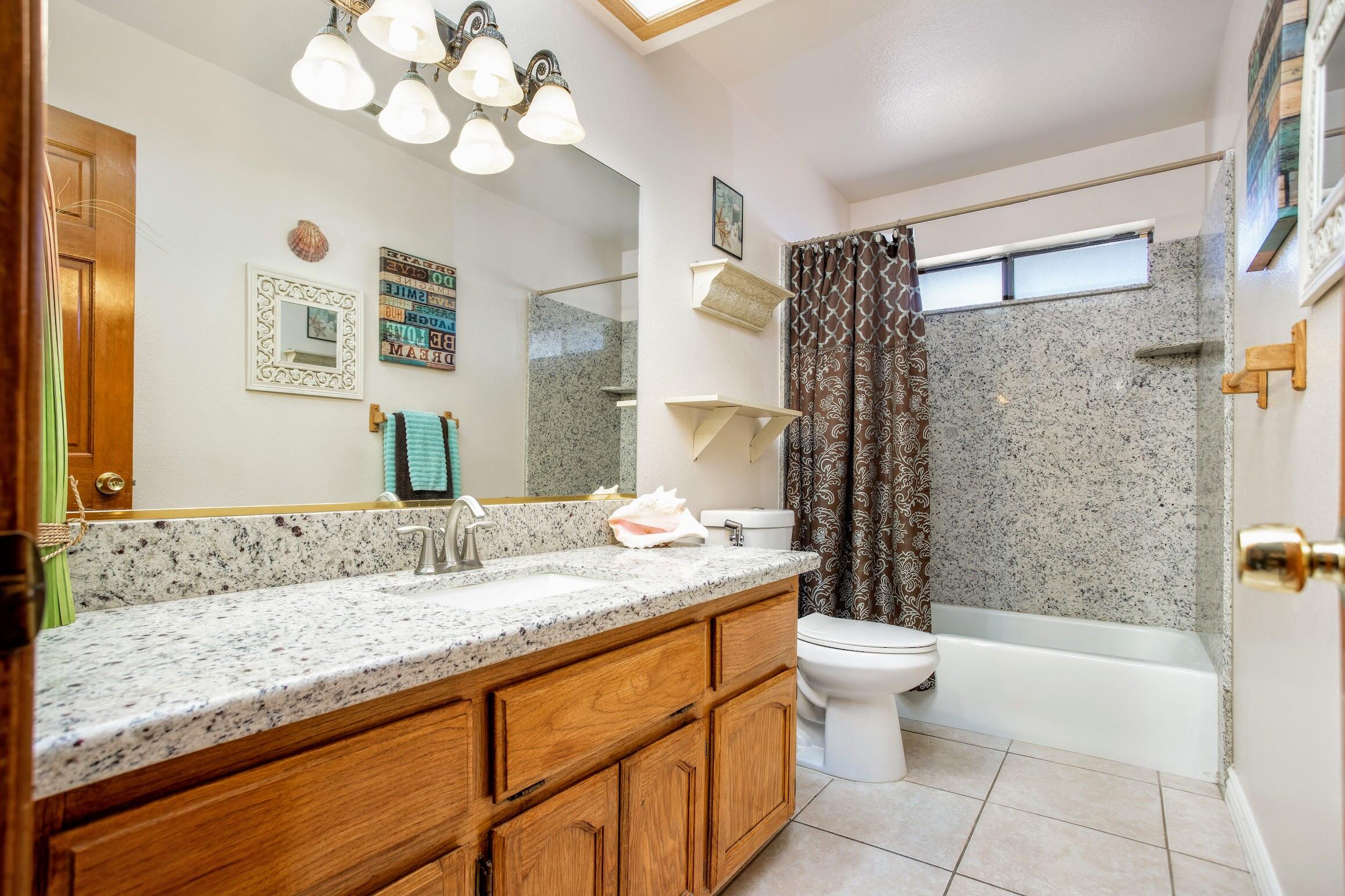 16276 Rancherias Road Apple Valley, CA 92307 - Photo 22 of 27 a bathroom with a granite countertop sink a toilet and bathtub