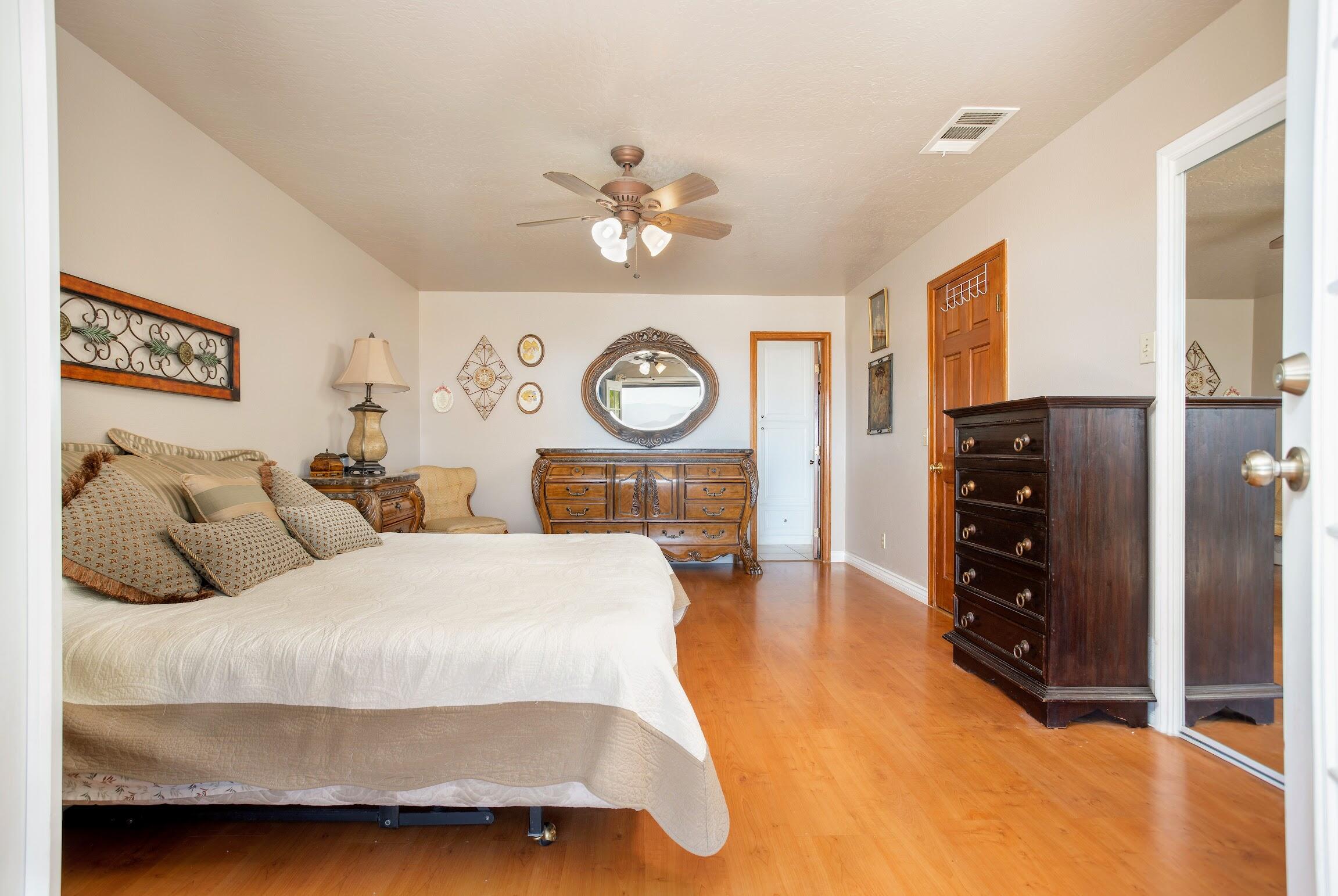 16276 Rancherias Road Apple Valley, CA 92307 - Photo 23 of 27 a bedroom with a bed and a chandelier