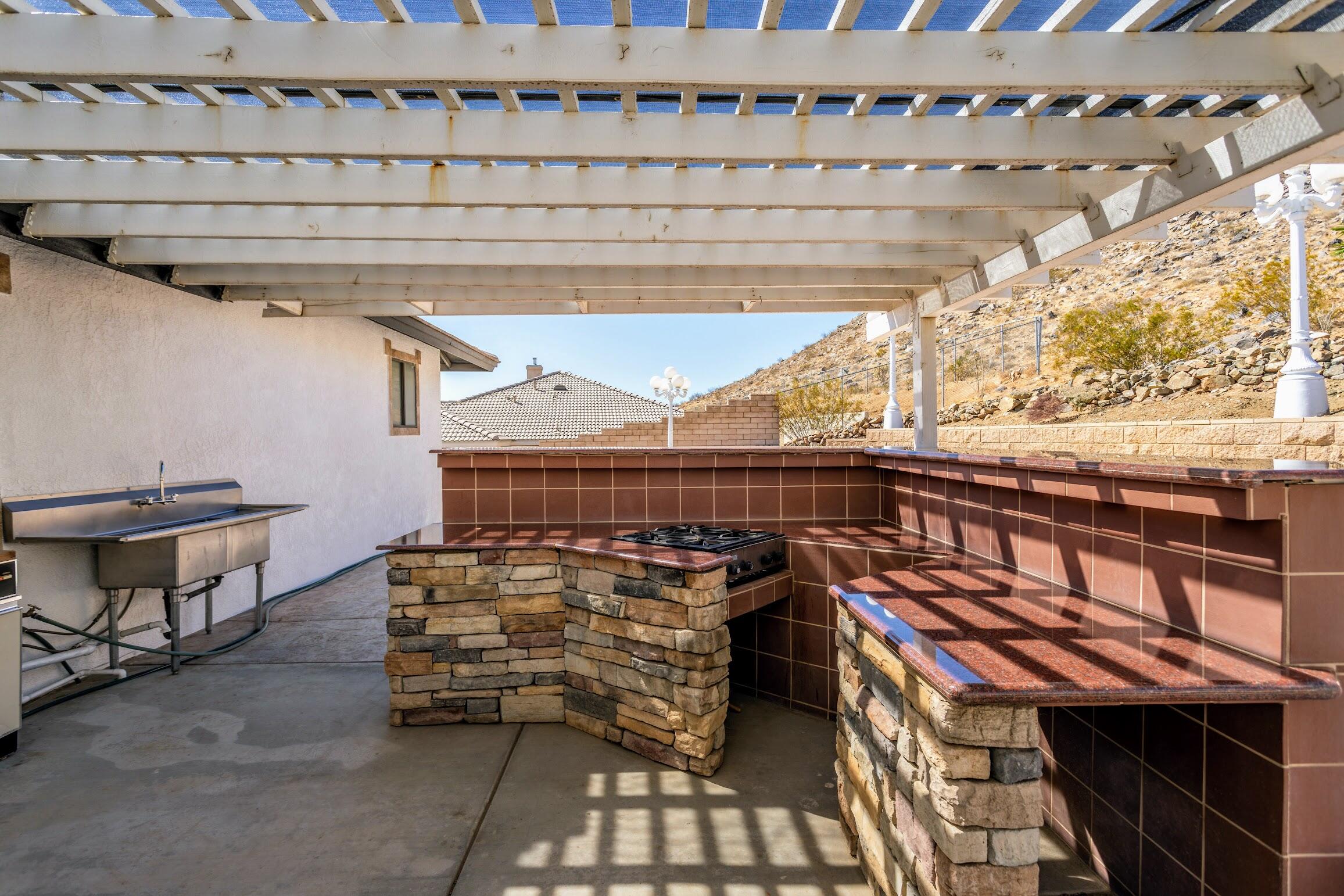 16276 Rancherias Road Apple Valley, CA 92307 - Photo 25 of 27 a view of a patio with table and chairs