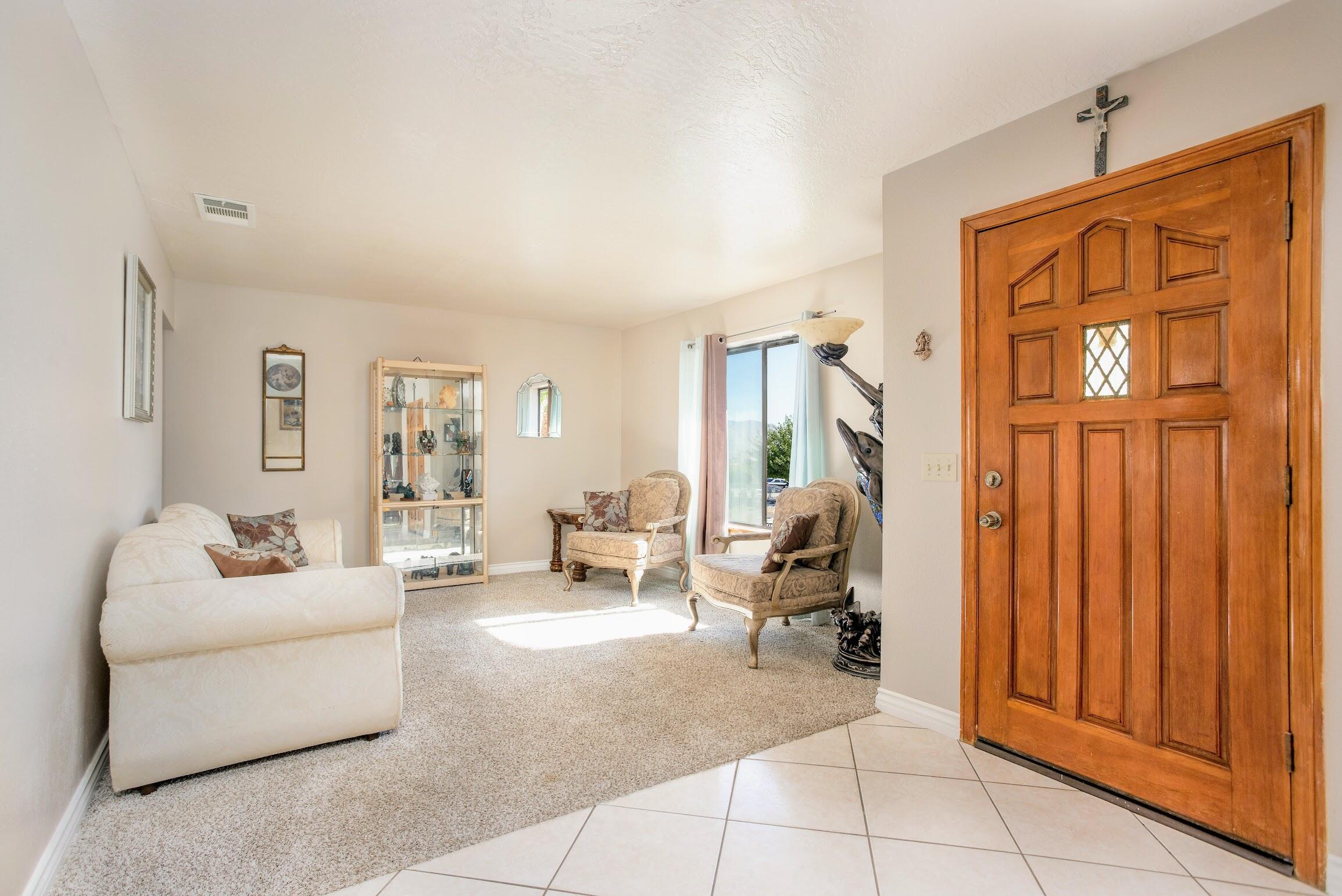 16276 Rancherias Road Apple Valley, CA 92307 - Photo 6 of 27 a living room with furniture a window and gym equipment