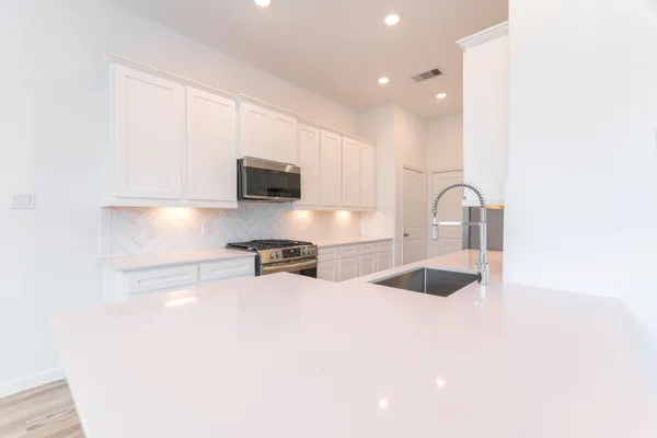 a view of kitchen with sink and refrigerator