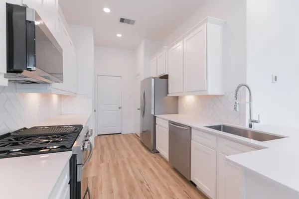 a kitchen with a sink a stove and cabinets
