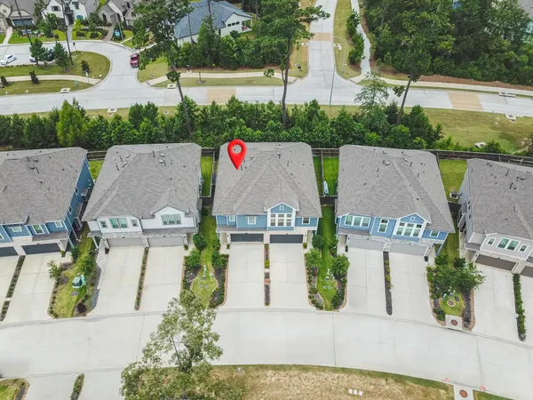 an aerial view of a house with large trees and plants next to a yard