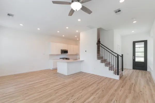 a view of an empty room with a window and wooden floor