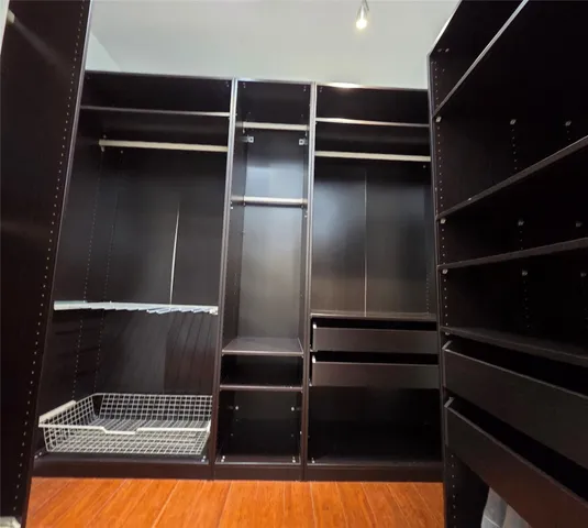 a room with walk in closet and wooden floor