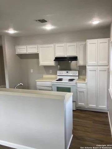 a kitchen with kitchen island a sink a stove a refrigerator and cabinets