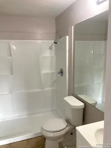 a white toilet sitting next to a bathroom sink and shower
